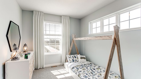 Carpeted secondary bedroom with standard closet.