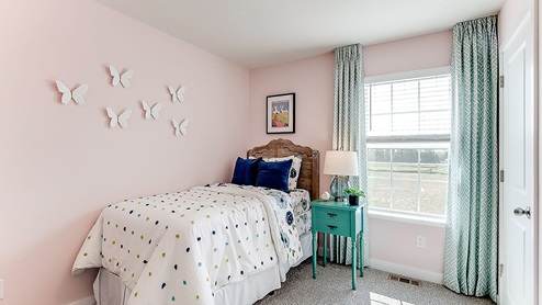 Carpeted secondary bedroom with standard closet.