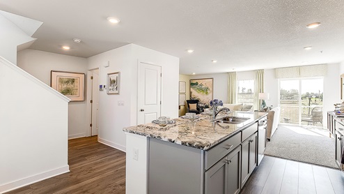 Open concept main level with view of kitchen and living room.