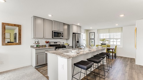 Open concept main level with view of kitchen and dinette.