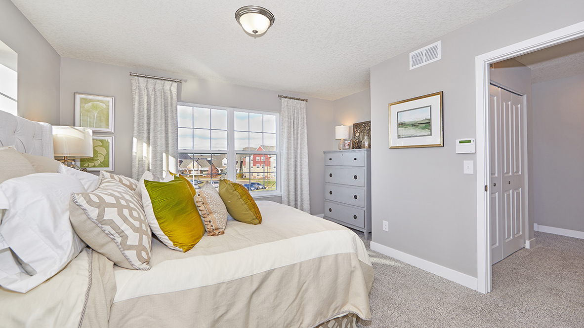 Carpeted bedroom suite with walk-in closet and private bathroom.