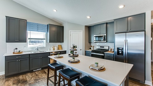 Spacious kitchen with stainless appliances and stunning dark gray cabinetry.