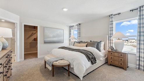 bedroom with a white bed, with night stands and windows on either side and a brown dresser across