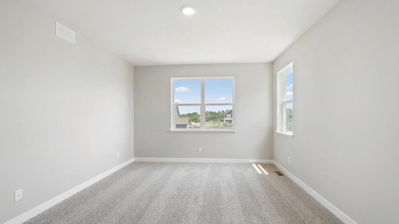bedroom with beige carpet, grey walls and a window