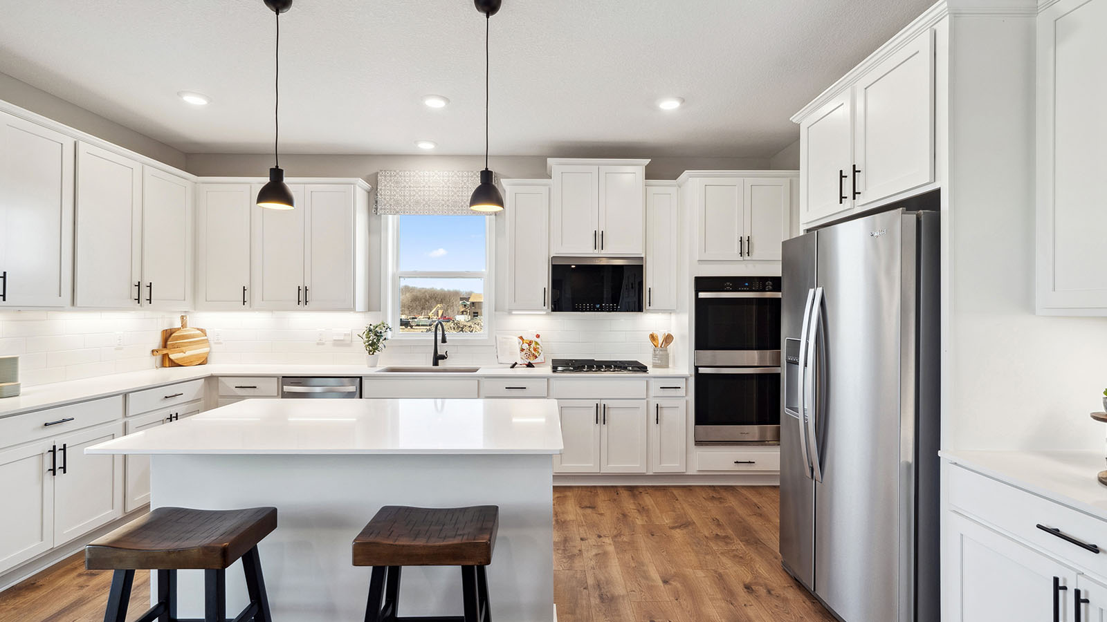kitchen with white cabinetry, large island, and stainless steel appliances