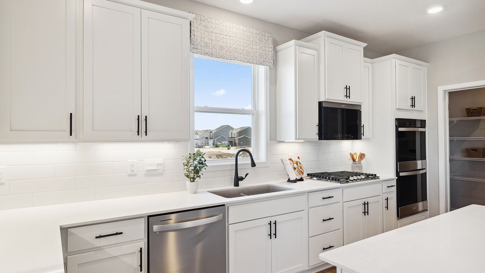 kitchen with white cabinetry, large island, and stainless steel appliances