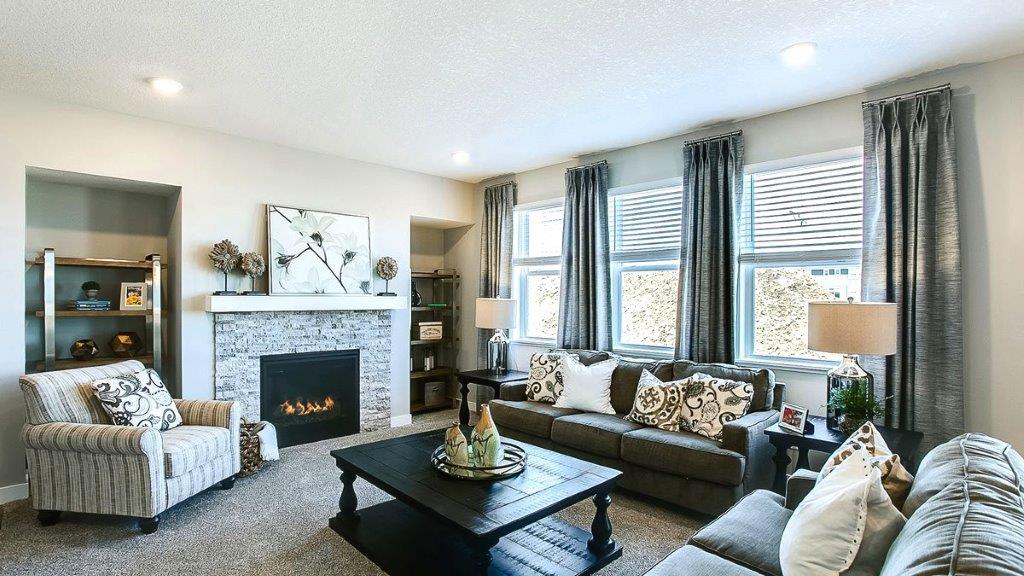 Carpeted living room with gas fireplace.