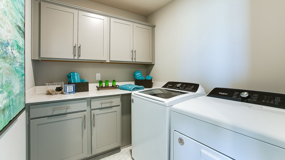 Upper level laundry room with willow gray cabinets and quartz countertops.