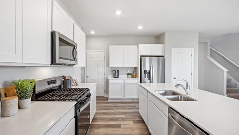 The kitchen features stainless appliances and quartz countertops.