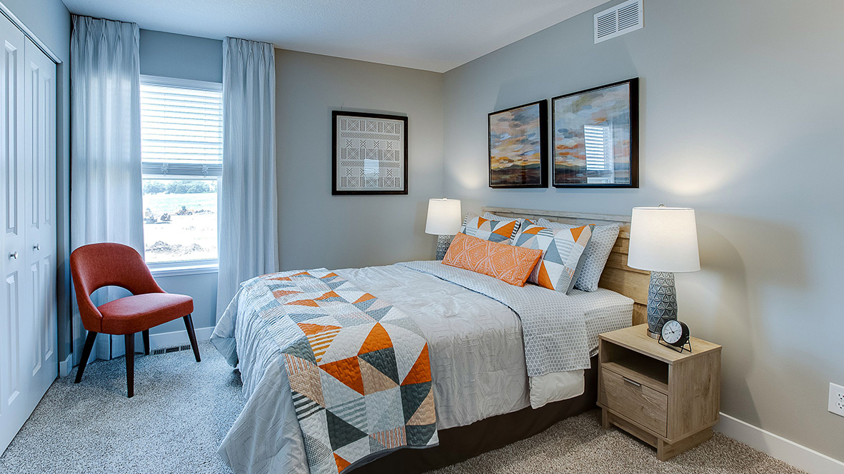 bedroom with beige carpet, grey walls and a window