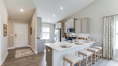 The model kitchen is of a Bryant II plan and includes quartz countertops and stainless appliances.