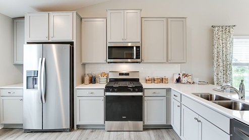 The model kitchen is of a Bryant II plan and includes quartz countertops and stainless appliances.