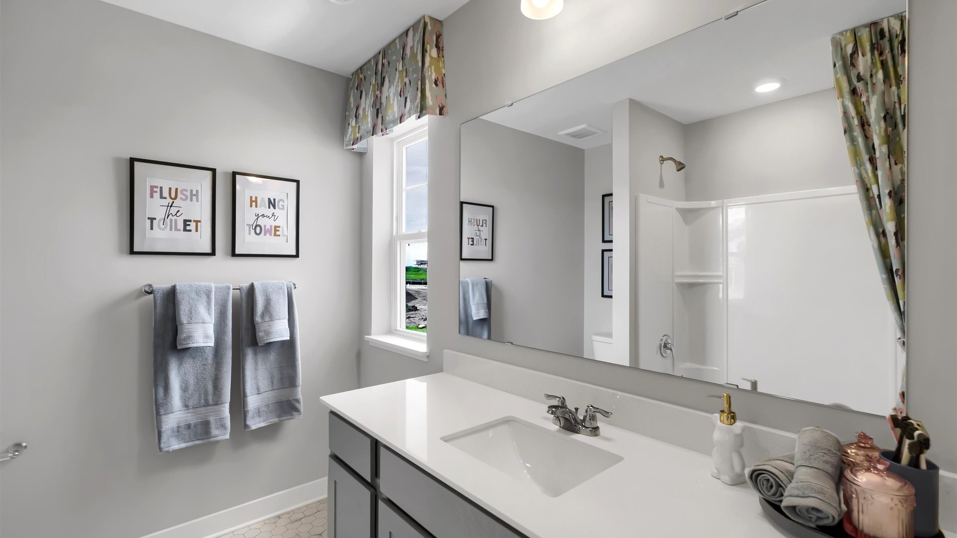 Secondary bathroom with gray cabinetry and quartz vanity countertop.