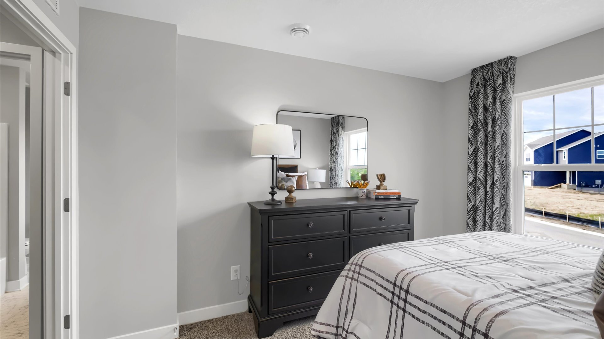 bedroom with beige carpet, white walls and a window