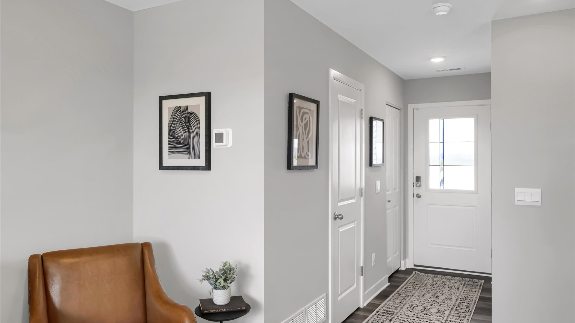 front entry way of home featuring brown flooring and white walls