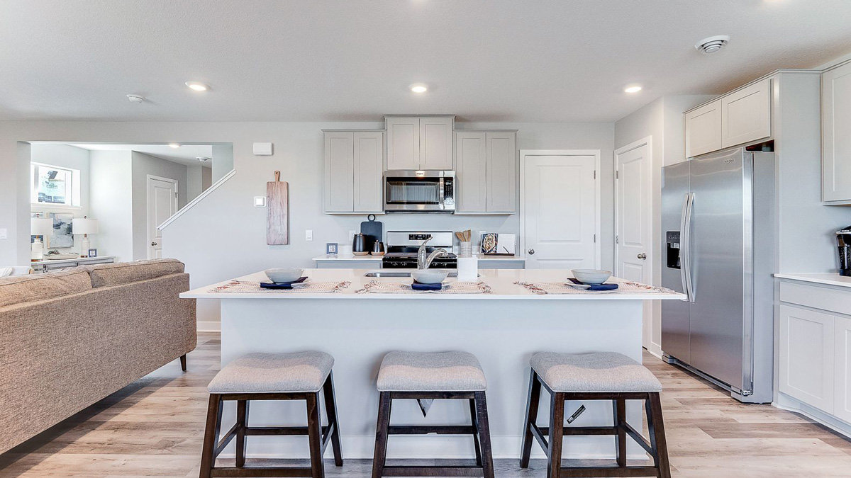 Straight-on view of kitchen, with four-person island in foreground.