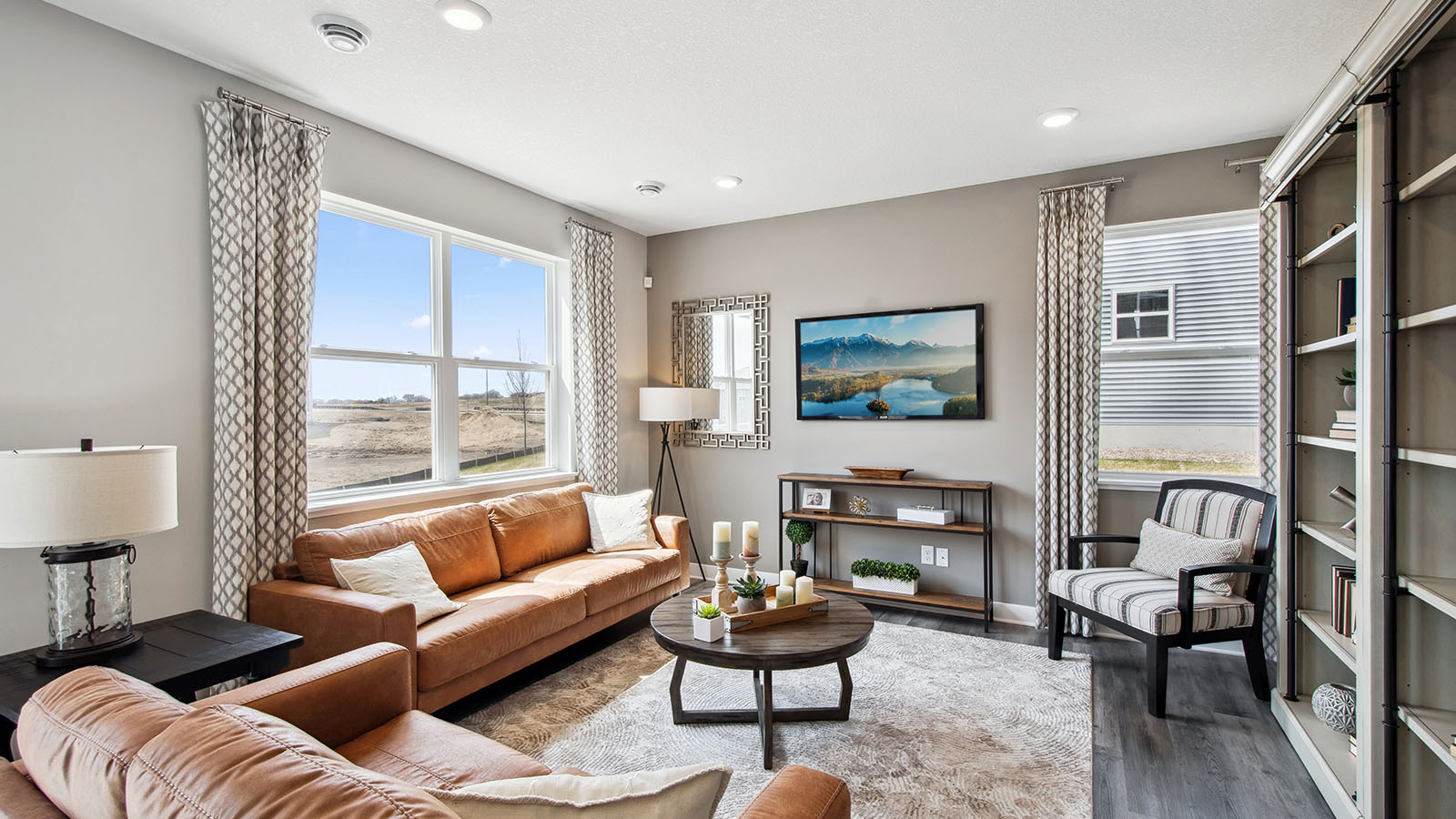 Living room on open concept main level with hard flooring.