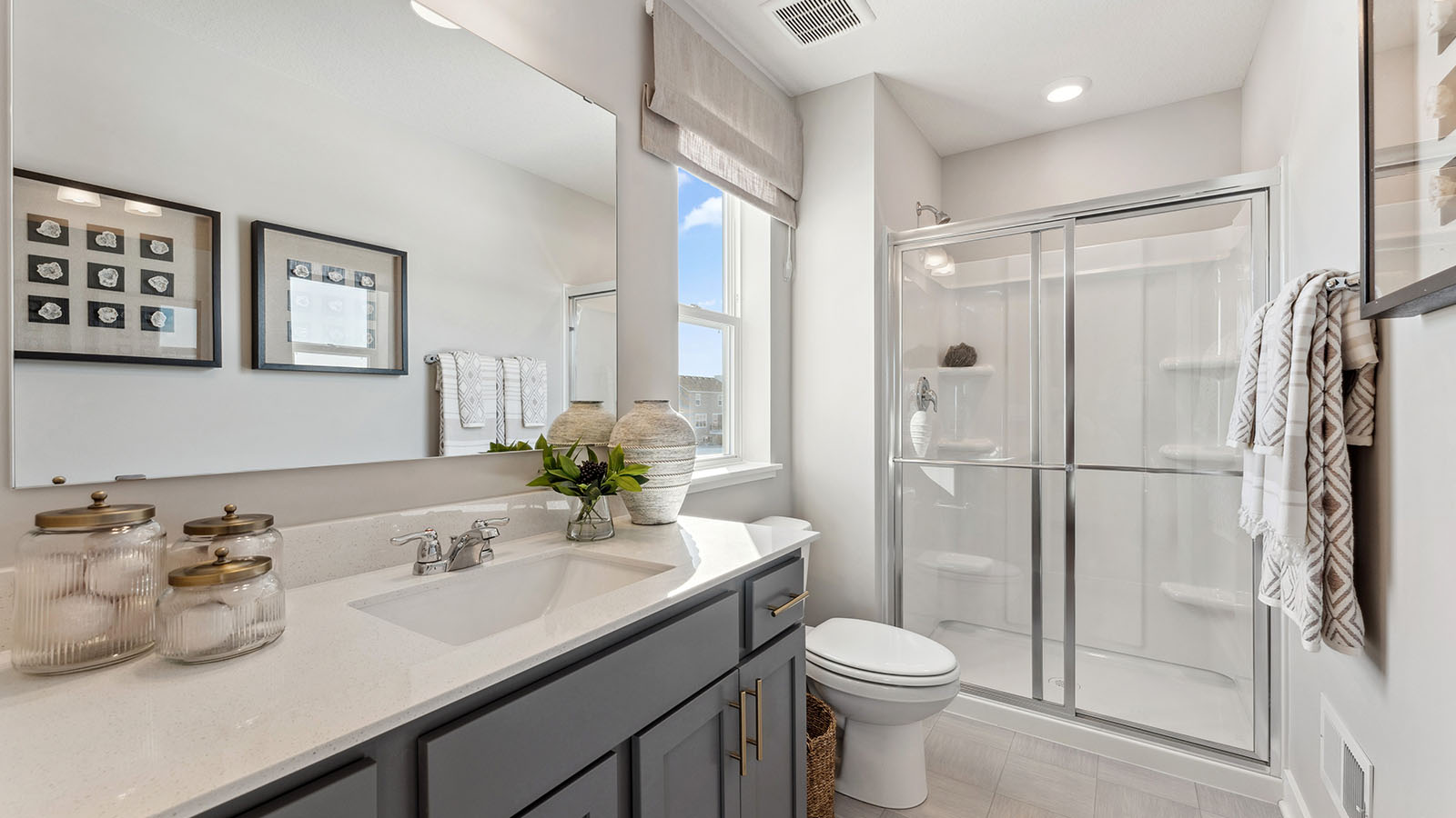 Bedroom suite's private bathroom with harbor gray double sink vanity and separate shower and soaking tub