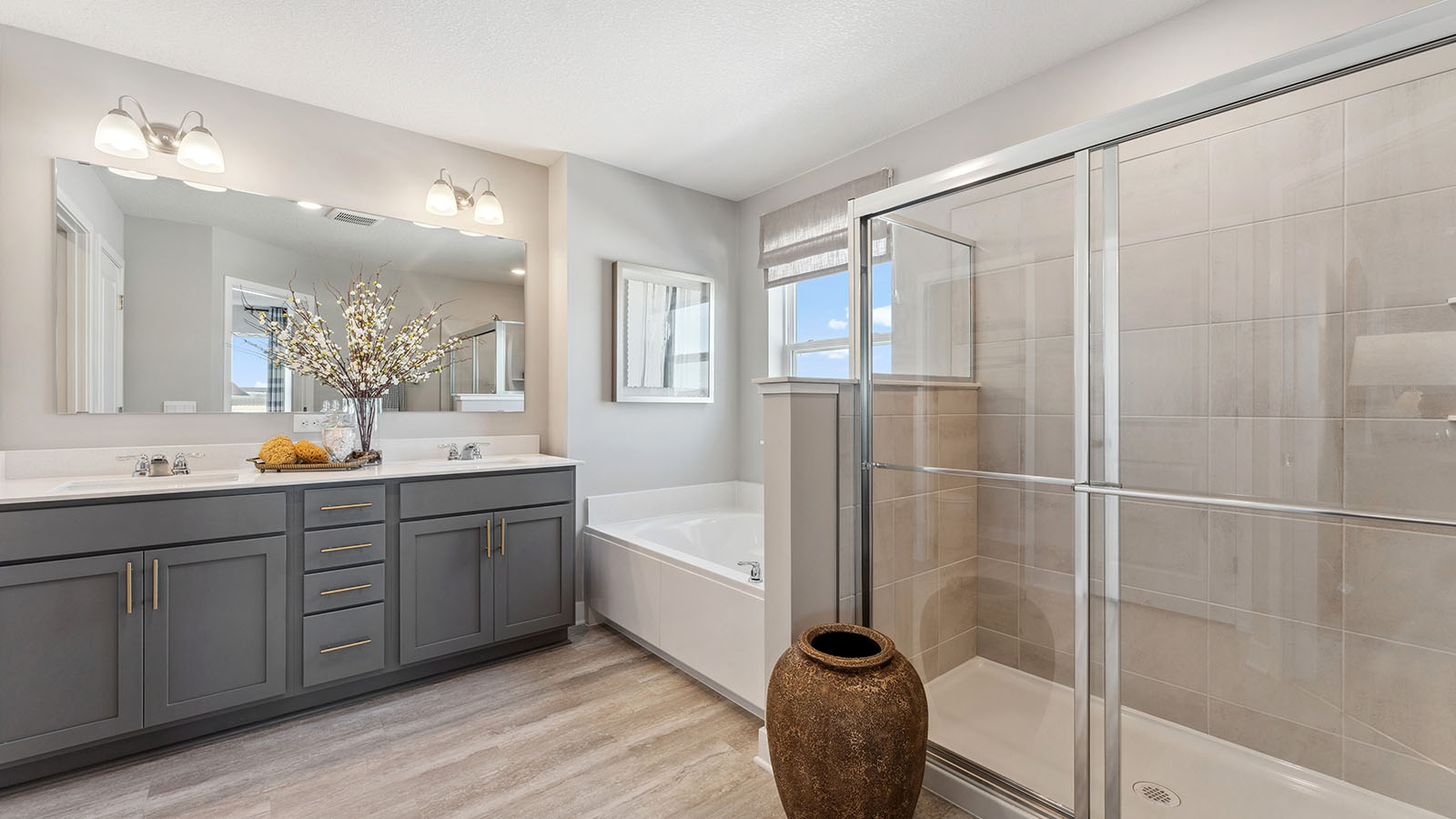 Bedroom suite's private bathroom with harbor gray double sink vanity and separate shower and soaking tub