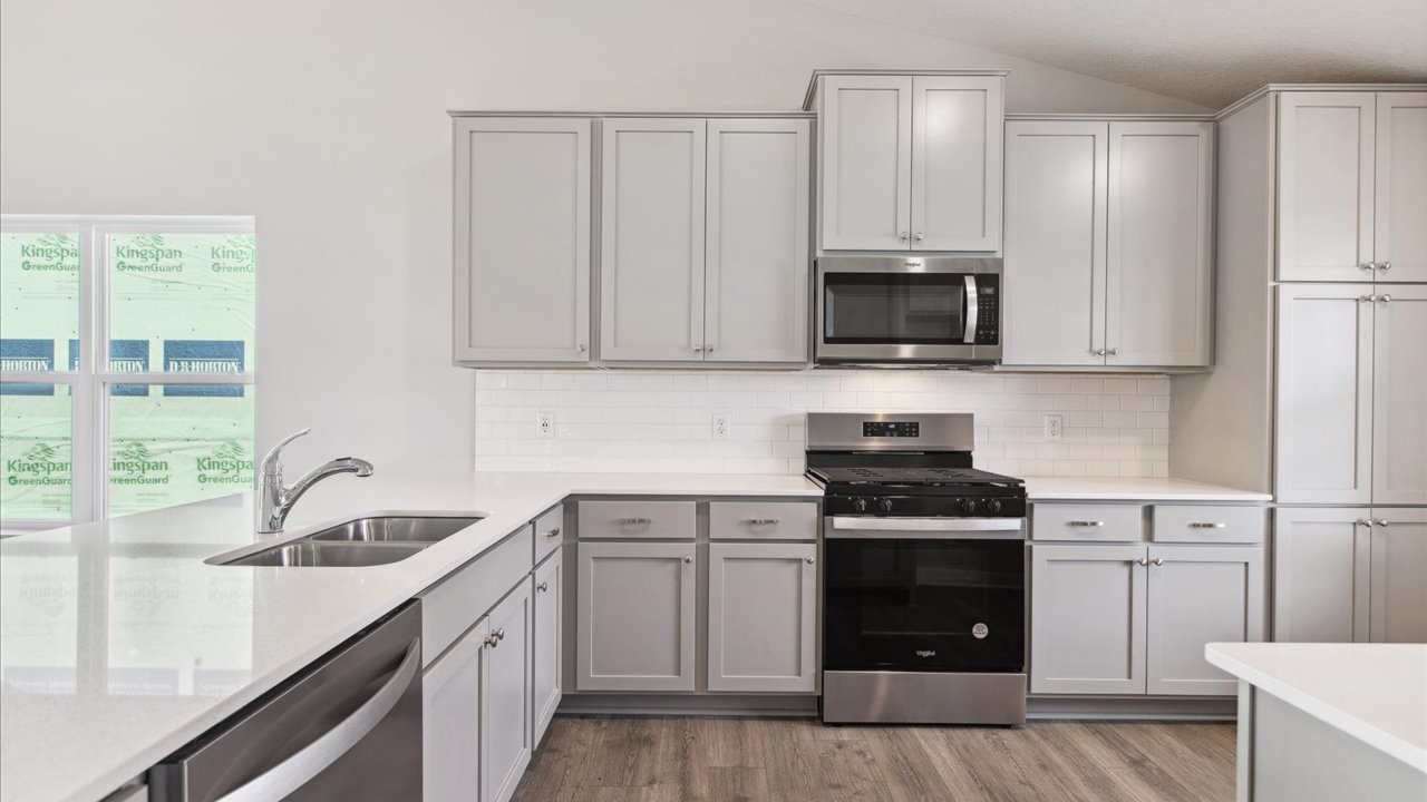 Kitchen with gray cabinets and stainless steel appliances.