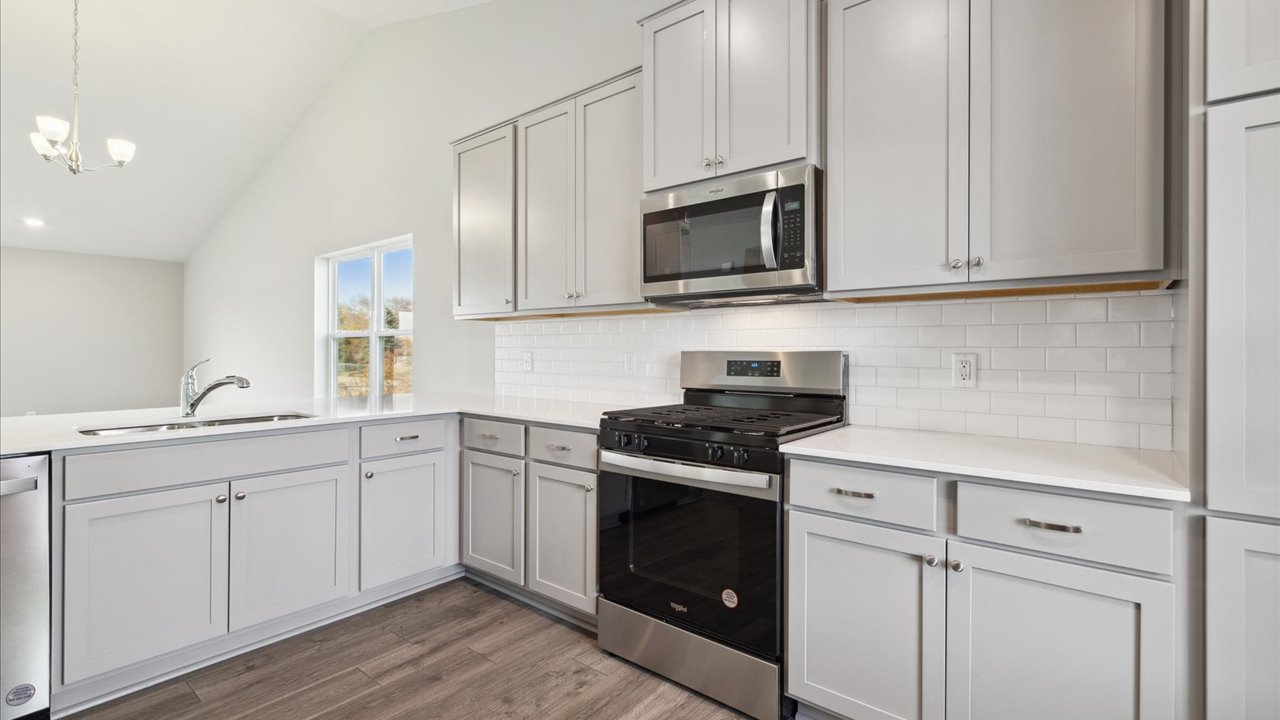 Kitchen with gray cabinets and stainless steel appliances.