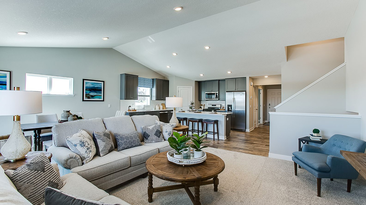 Open concept main level with view of kitchen island, living room and dinette.