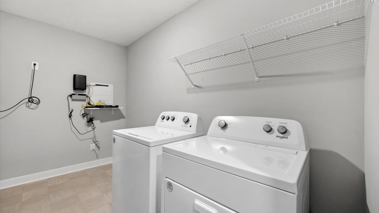 Upper level laundry room with wire shelving unit.