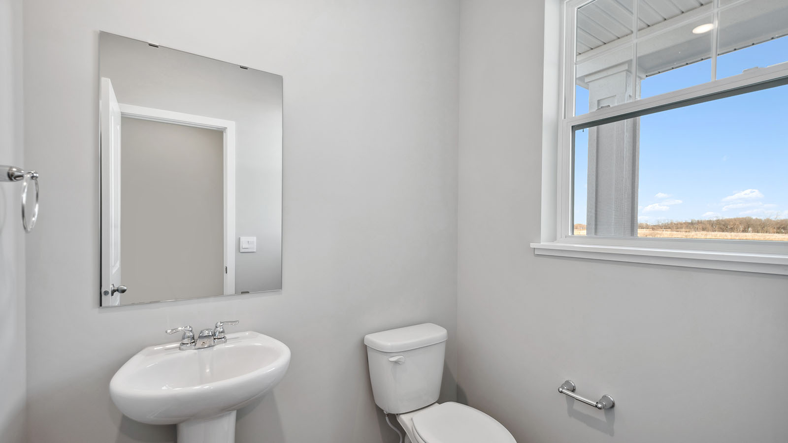 Half bath on main level with mirror and pedistal sink brushed nickle fixtures Harvest View By D.R. Horton