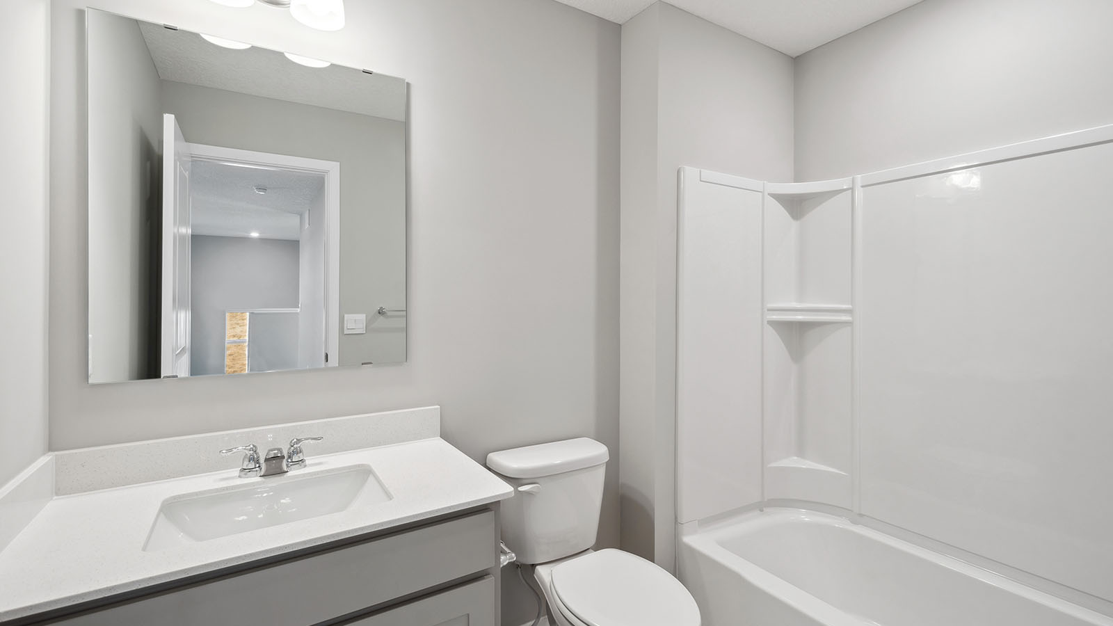 Family full bathroom 2 with stylish vanity, mirror, polished fixtures, cabinets, tub-shower combo Harvest View By D.R. Horton