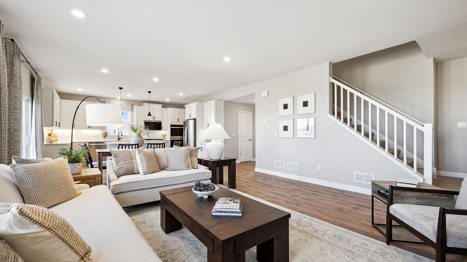 Living room design showcases central access to kitchen, dining, stairs, and main living areas