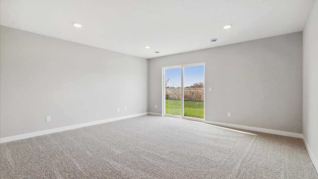 Carpeted living space in walkout style lower level.