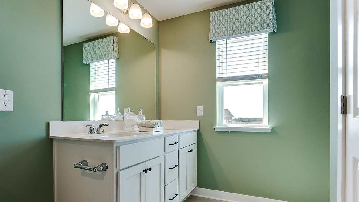 Private bathroom with white double sink vanity and quartz vanity countertop.