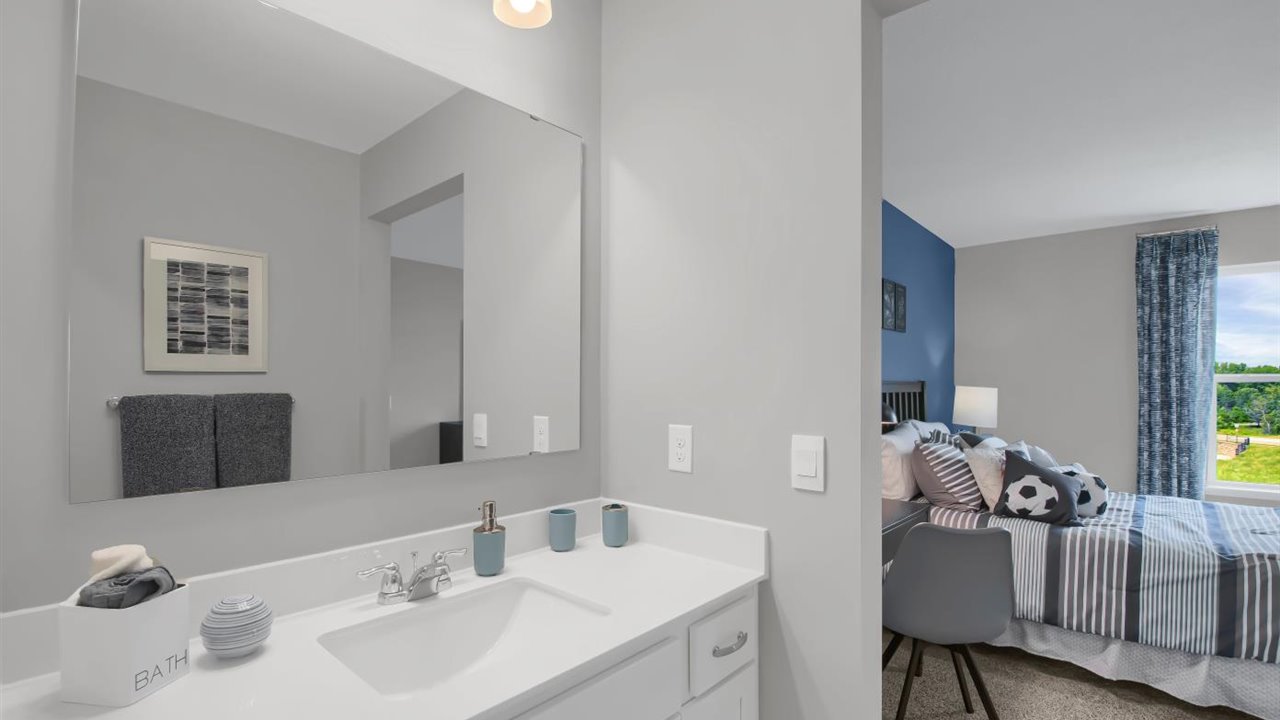 Jack and Jill bathroom with white cabinets and quartz countertops.