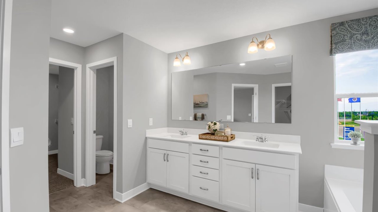 Bedroom suite's private bathroom leading into walk in closet.