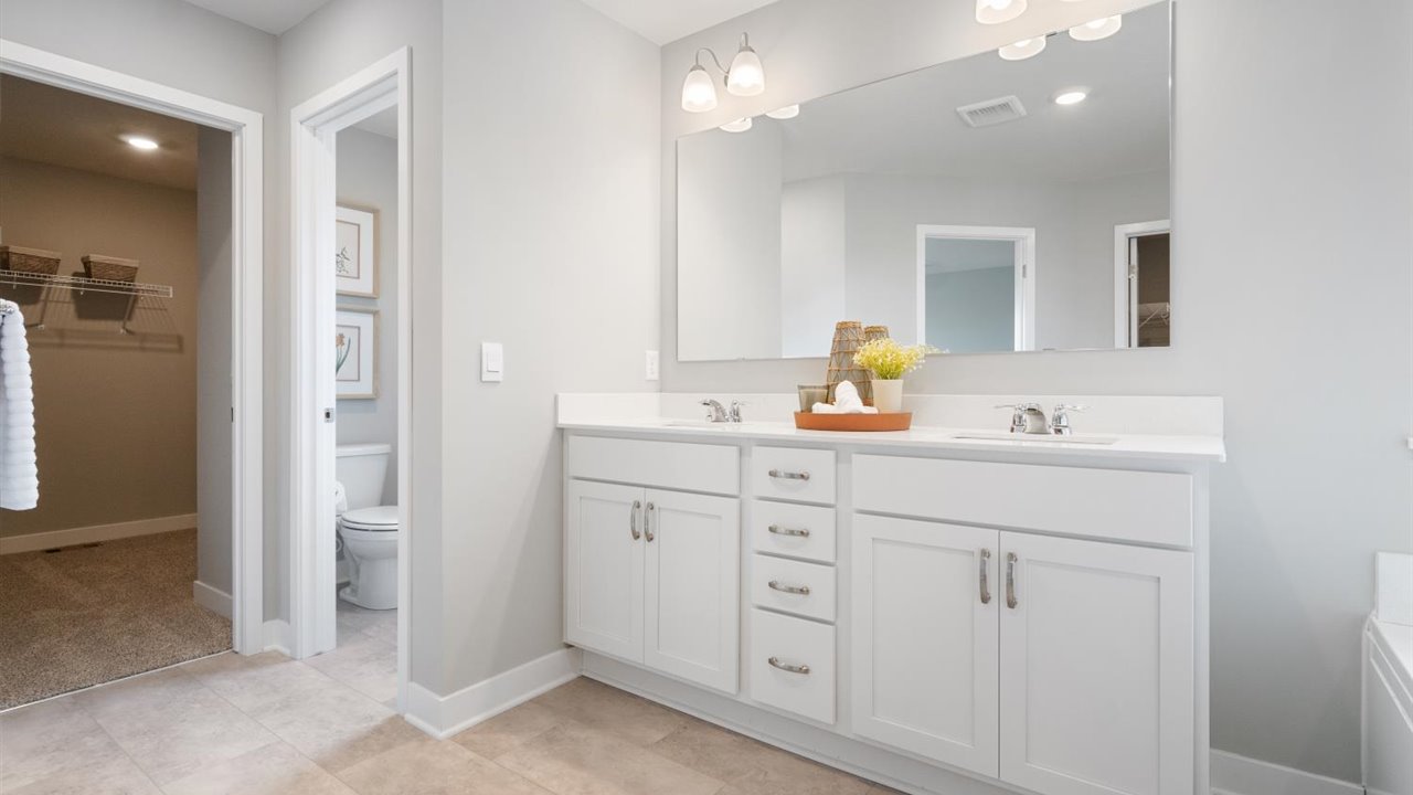 Private bathroom with white cabinets and separate shower and soaking tub.