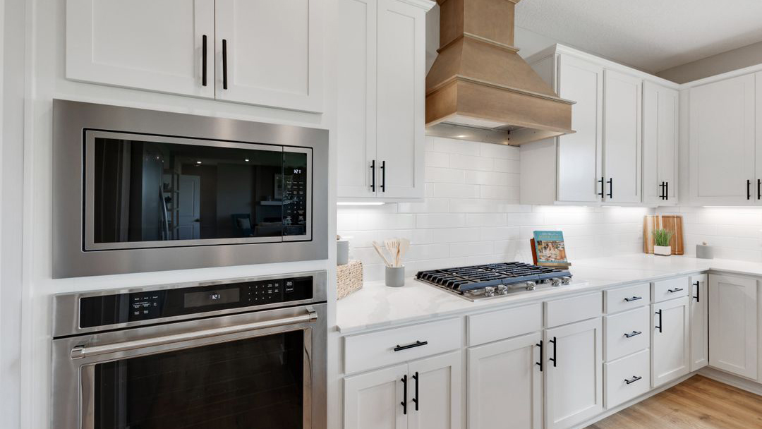 Kitchen with white cabinetry, island, and included appliance package Prairie Pointe