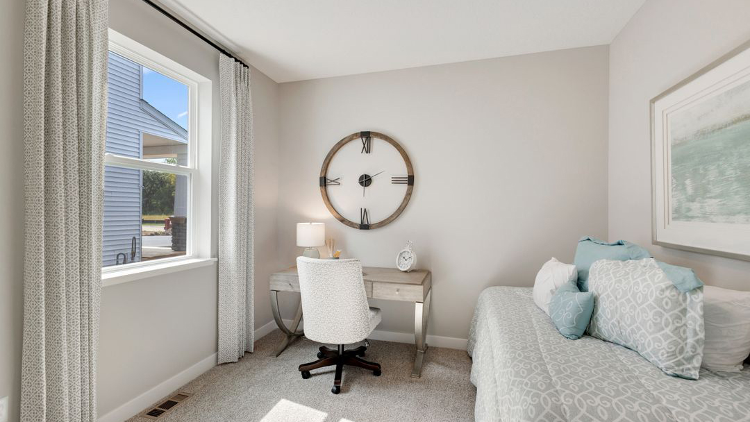 Bedroom 2 with a large window and neutral staging Prairie Pointe