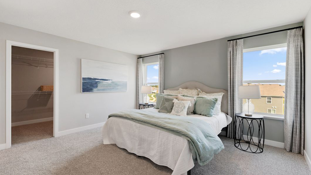 Bedroom 2 with a large window and neutral staging Prairie Pointe