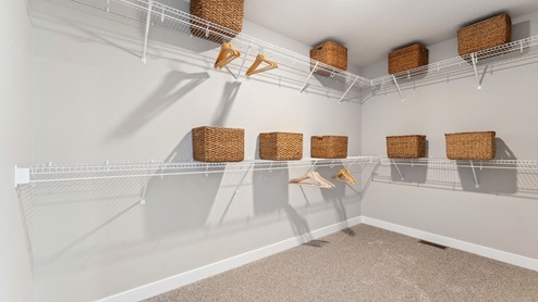 Open walk-in closet entry from en suite bath with organized shelf layout at Anton Village