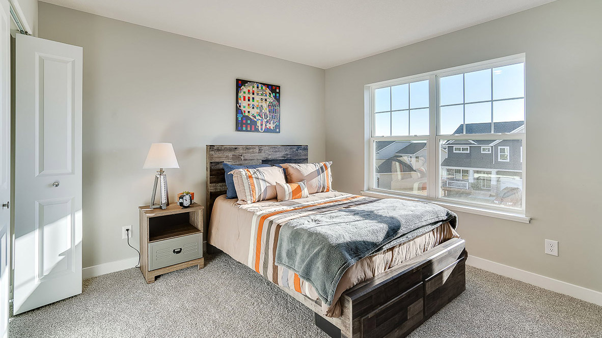 Secondary Bedroom in this Anton Village Adams II Plan home showcases plush flooring, single door closet, and convenient hallway access