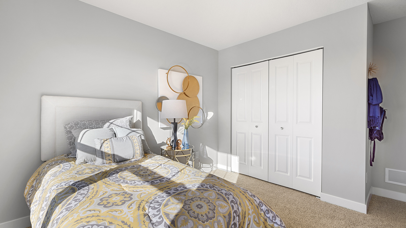 Carpeted secondary bedroom with standard size closet.