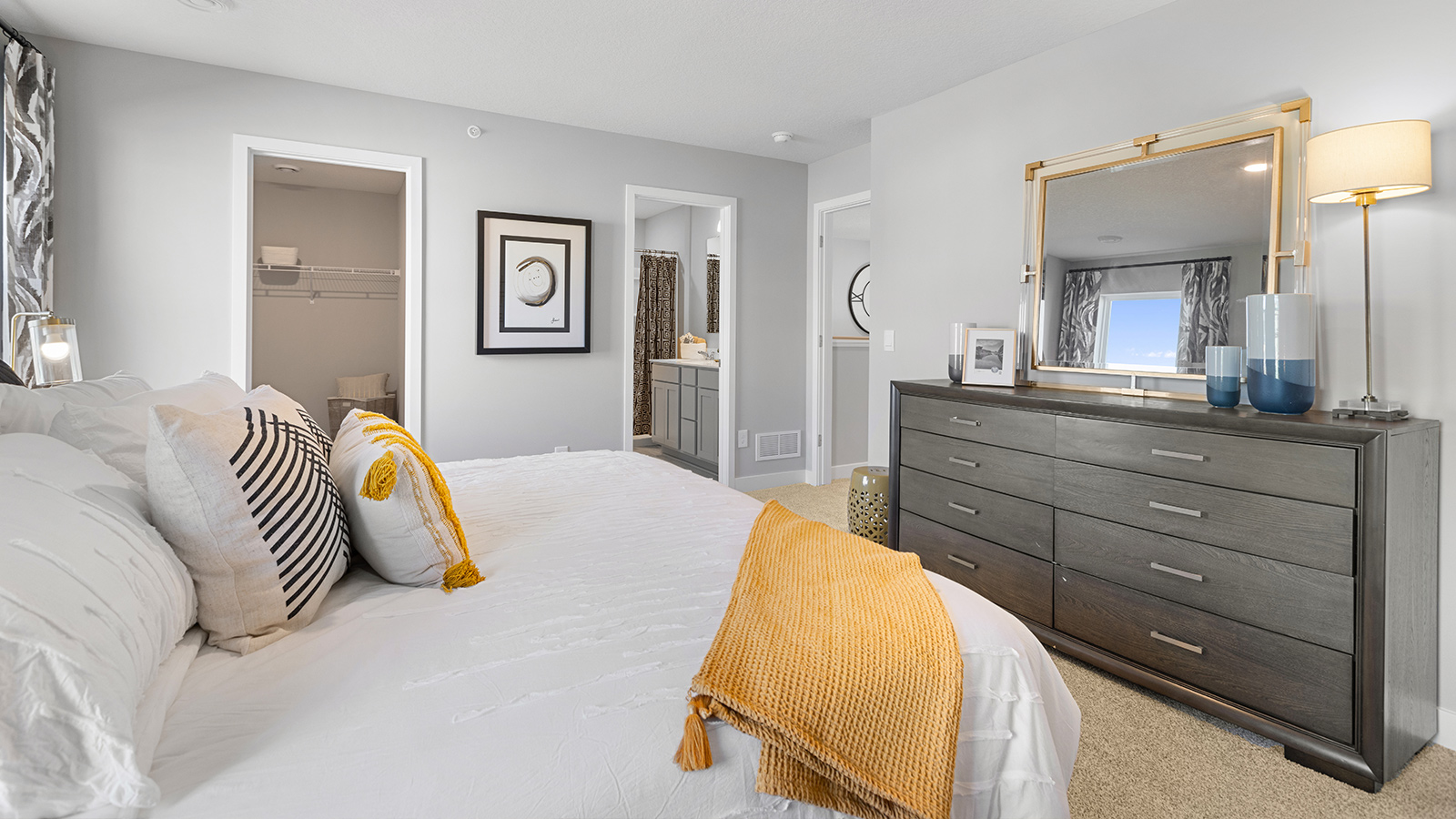 Carpeted bedroom suite with private bathroom and walk in closet.