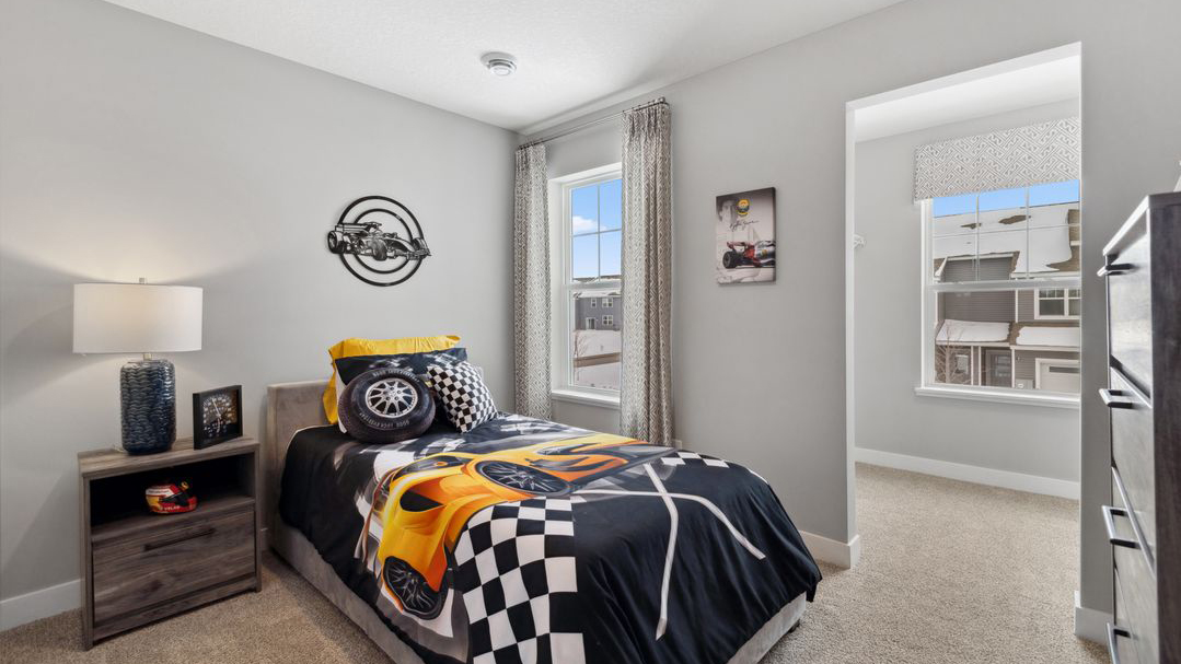 Carpeted secondary bedroom with standard size closet.
