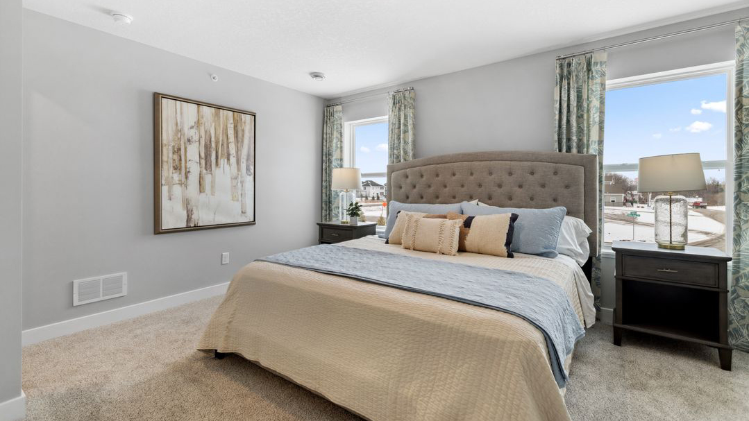 Carpeted bedroom suite with private bathroom and walk in closet.