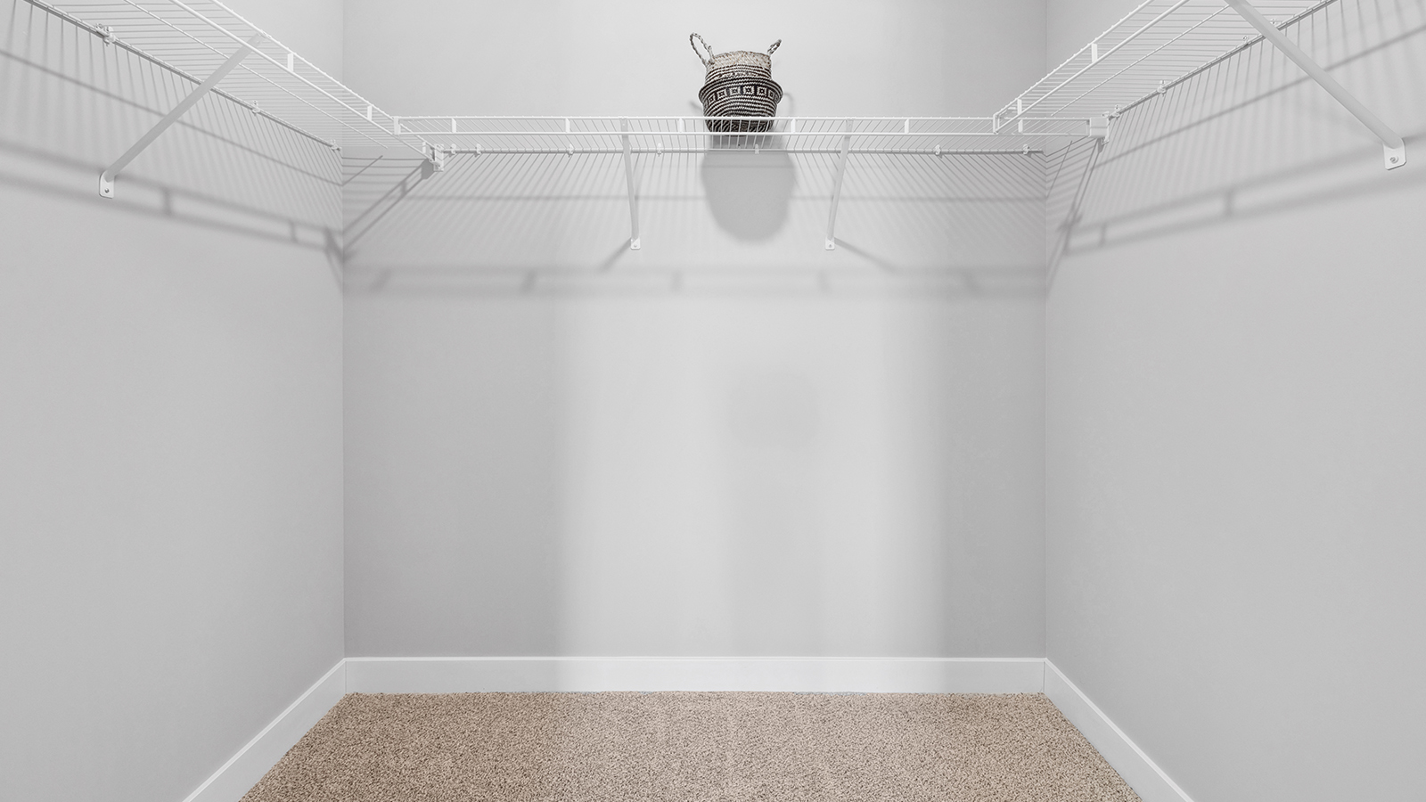 Bedroom suite's walk in closet with wire shelving unit.