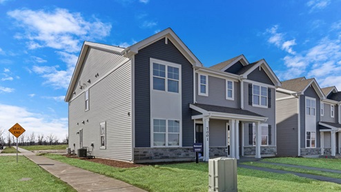 Two story attached condo with vinyl siding and stone accents