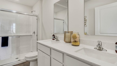 Primary bathroom with dual vanity sinks and walk in shower