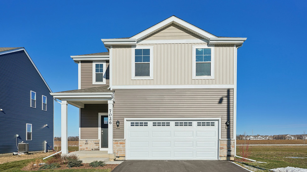 Exterior of two story sloan model with vinyl and brick siding