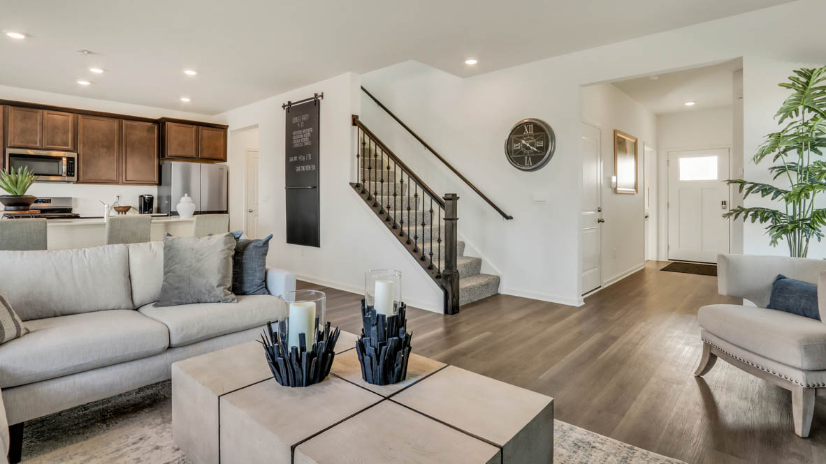 Great room view of staircase with iron railing and hallway view