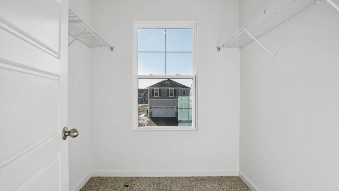 spacious walk in primary closet with window